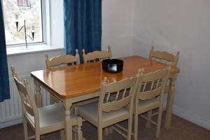 a wooden dining room table with chairs and a bowl on it at Seaside 3 Bed Killybegs Property on Main Street in Killybegs