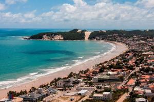 een luchtzicht op een strand met huizen en de oceaan bij Casa confortável à 568m da praia de Ponta Negra in Natal