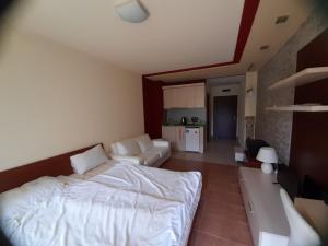 a bedroom with a bed and a living room at Green Life Beach Resort Private Studio Flat First Line Kavatsi Smokinya Beach Sozopol in Sozopol