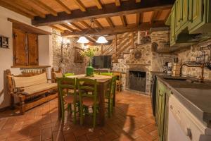 uma cozinha com uma mesa e cadeiras e uma lareira em Agriturismo Monte Croce em Stazzema