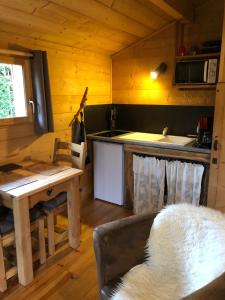 una cocina con sofá y mesa en una cabaña en La Cabane du Trappeur, en Ore