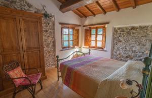 - une chambre avec un lit et une chaise dans l'établissement Agriturismo Monte Croce, à Stazzema