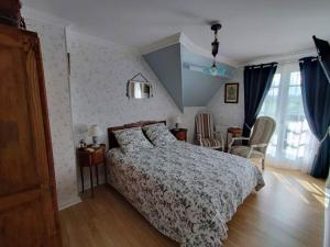 a bedroom with a bed and a table and chairs at L'ABRIGIT in Curcy-sur-Orne