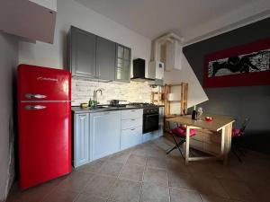 una cucina con frigorifero rosso e tavolo in legno di Appartamento A&S-Centro Argenta ad Argenta