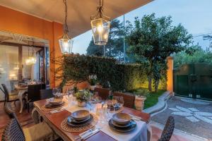 une salle à manger avec une table, des chaises et une grande fenêtre dans l'établissement Corallina, 2 Bedrooms Villa with Garden and Private Jacuzzi, à Torvaianica