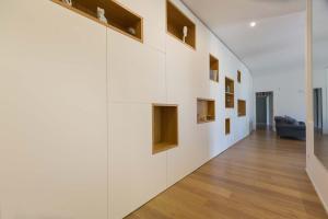 Un pasillo con paredes blancas y suelos de madera. en Sweet Home Suite, en Lecce 13 fotos más