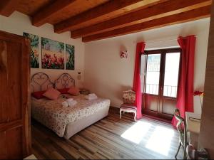 パレルモにあるCasa Busariのベッドルーム1室(ベッド1台付)、赤いカーテン付きの窓が備わります。