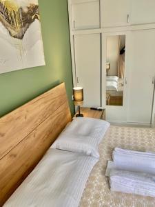 um quarto com uma cama com lençóis brancos e um espelho em Athens nice apartment em Atenas