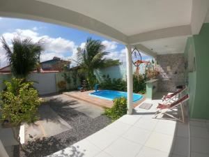 eine Terrasse mit einem Pool im Hof in der Unterkunft Casa para Família com Piscina in Luis Correia