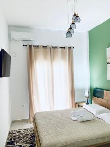 a bedroom with a bed and a window with curtains at Athens nice apartment in Athens