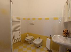 Łazienka z białą toaletą i umywalką w obiekcie Agriturismo Biofattoria l'Upupa w mieście Montalcino