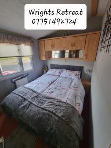 a bedroom with a bed in a small room at Wrights Retreat 4 Lunan View St Cyrus Caravan Park in Saint Cyrus