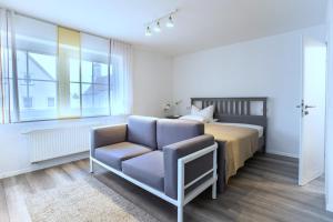 1 dormitorio con 1 cama y 1 silla en Apartmentvermietung Ingrid Bolkart - Vöhlino 2, en Illertissen