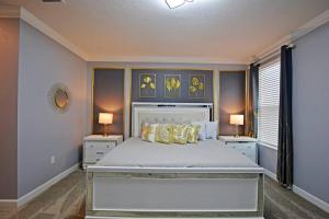 a bedroom with a large bed with two tables and two lamps at Amazing 6BR Villa @ Storey Lake Resort Near Disney in Kissimmee