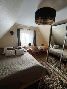 a bedroom with a large bed and a mirror at Noclegi u Ewy in Witów