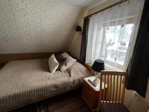 a small bedroom with a bed and a window at Noclegi u Ewy in Witów