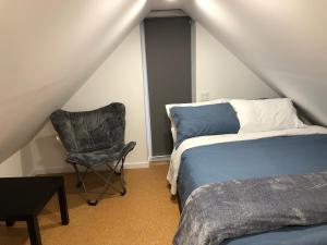 1 dormitorio con 1 cama y 1 silla en Well Equipped Studio FOR NON-SMOKING GUESTS ONLY CITQ ЗO9467 en Longueuil