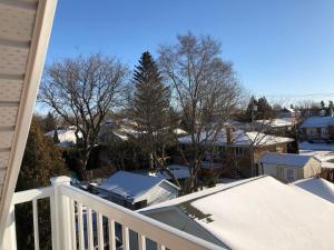 a balcony with snow on the roofs of houses at Well Equipped Studio FOR NON-SMOKING GUESTS ONLY CITQ ЗO9467 in Longueuil