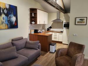 a living room with a couch and chairs and a kitchen at Appartement - B&B 'la bienvenue' in Venlo, Limburg in Venlo