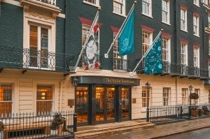 un bâtiment avec drapeaux devant lui dans l'établissement The Mayfair Townhouse - an Iconic Luxury Hotel, à Londres