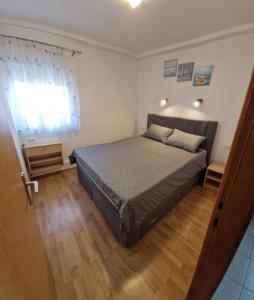 una camera con letto e pavimento in legno di Apartments Vuceric a Peroj