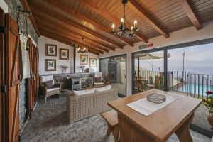 ein Wohnzimmer mit Tisch und Kamin in der Unterkunft Refúgio da Serra - By WeHost in Ribeira do Raposo