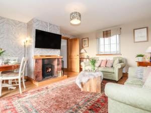a living room with a couch and a fireplace at Grey Craig Cottage in Lockerbie