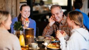 a group of people sitting around a table eating food at Hovdestøylen in Hovden