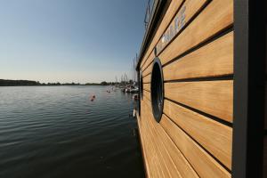 a boat is docked on a body of water at Houseboat in Wolin