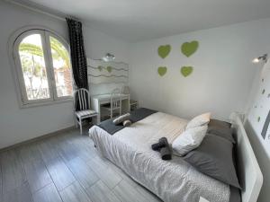 New Pistachio Apartment في كوستا تاغيسي: غرفة نوم مع سرير ونافذة مع قلوب على الحائط