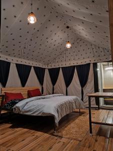 een slaapkamer met een plafond met sterren erop bij Imilia Camps in Bir