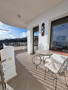 een patio met een tafel en stoelen op een balkon bij Vue magnifique mer et montagne in Salobreña