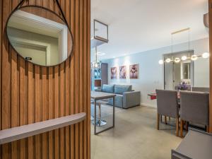 a mirror on a wall next to a living room at Volo Class 308 - A poucos passos Catedral de Pedra in Canela