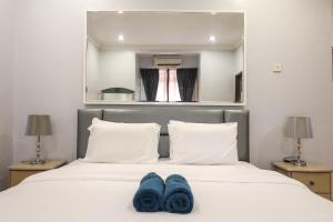 Una cama con dos pares de zapatos azules. en Kota Damansara ICozy Cove Homestay 10 Pax en Petaling Jaya