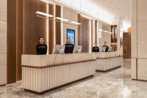 a group of people sitting at a counter with their laptops at Atour Hotel Dalian Development Zone in Dalian
