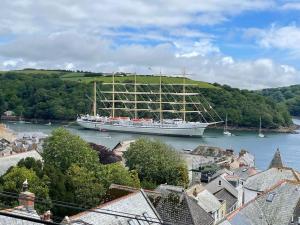 a large boat in the water next to a town at Marners Rock No 1 in Fowey