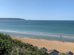 a beach with people standing in the water at Luxury Seaside Retreat Holiday Home - Shorefield Country Park in Downton