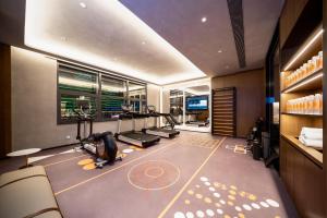 een fitnessruimte met loopbanden en crosstrainers in een kamer bij Atour Hotel Dalian Development Zone in Dalian