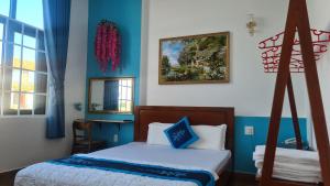 a bedroom with a bed with blue walls and a mirror at LẠI NGUYỄN BOUTIQUE HOTEL in Can Tho