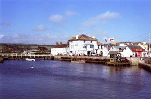 a river with a house and a dock with a boat at Chalet With Sea Views in West Bay