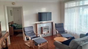 韋斯特貝的住宿－Chalet With Sea Views，客厅配有两把椅子和电视