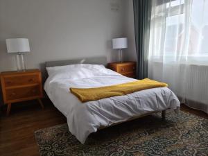 Un dormitorio con una cama con una manta amarilla. en Charming spacious 2 bed apartment in quiet area en Exhall