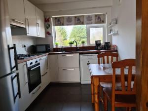 a kitchen with white appliances and a table and a window at Charming spacious 2 bed apartment in quiet area in Exhall
