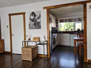 a kitchen with white cabinets and a table and a dining room at Charming spacious 2 bed apartment in quiet area in Exhall