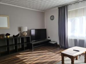 uma sala de estar com uma televisão de ecrã plano e uma mesa em Charming spacious 2 bed apartment in quiet area em Exhall