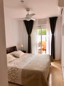 sypialnia z łóżkiem i wentylatorem sufitowym w obiekcie Apartment Costa del Sol, Manilva, Duquesa w mieście Castillo de Sabinillas