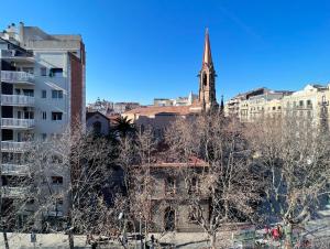 an old church with a steeple in a city at Stay U-nique Apartments Casanova in Barcelona