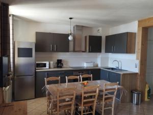 a kitchen with a table and chairs and a refrigerator at Le gîte du Val in Flumet