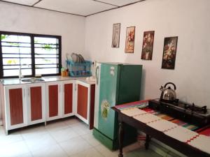 a kitchen with a green refrigerator and a table at Dinky in Hikkaduwa