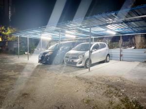 two cars parked in a parking lot at night at MN Ferringhi Inn in Batu Ferringhi